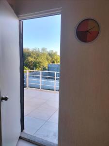 eine Tür, die auf einen Balkon mit einer Uhr führt in der Unterkunft Apartamento Cadereyta 