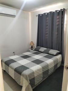 ein Schlafzimmer mit einem schwarz-weiß karierten Bett in der Unterkunft Apartamento Cadereyta 
