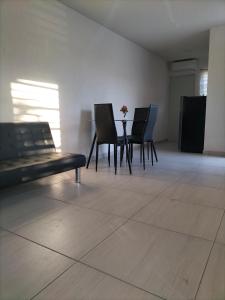 ein Zimmer mit Stühlen und einem Tisch mit einer Blumenvase in der Unterkunft Apartamento Cadereyta 