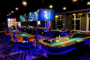 un casino avec des tables et des chaises et un jeu vidéo dans l'établissement Hampton Inn at Tin Lizzie Gaming Resort, à Deadwood