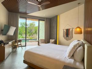 ein Hotelzimmer mit einem Bett, einem Schreibtisch und einem Zimmer in der Unterkunft Secrets Tulum Resort & Beach Club - Adults Only - All Inclusive in Tulum
