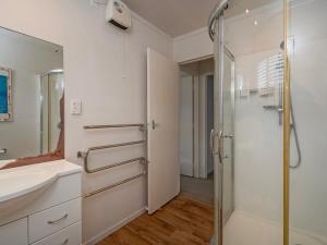 a bathroom with a shower and a sink at Kon Tiki Retreat - Whiritoa Beach Holiday Home in Whiritoa