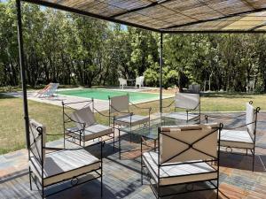 grupa krzeseł ustawionych pod baldachimem w pobliżu basenu w obiekcie Villa 4* pour 6 pers. avec piscine privée et grand jardin, proche gorges de l'Ardèche - FR-1-382-191 w mieście Labastide-de-Virac