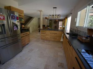 duża kuchnia z drewnianymi szafkami i lodówką ze stali nierdzewnej w obiekcie Villa 4* pour 6 pers. avec piscine privée et grand jardin, proche gorges de l'Ardèche - FR-1-382-191 w mieście Labastide-de-Virac +4 zdjęcia