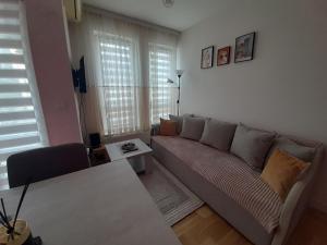 uma sala de estar com um sofá e uma mesa em Apartman Talija em Kragujevac