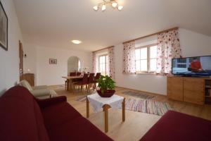 ein Wohnzimmer mit einem Sofa und einem Tisch in der Unterkunft Weinbachbauer - Urlaub am Bauernhof in St. Wolfgang