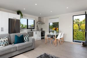 cocina y sala de estar con sofá y mesa en Luxury Apartment retreat, en Tauranga