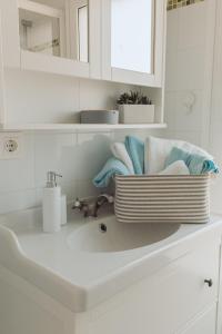 un lavabo blanco con toallas en la encimera en Casa Feliz - RentCar, en Calpe