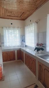 a large kitchen with wooden cabinets and windows at Greenview Homes in Eldoret