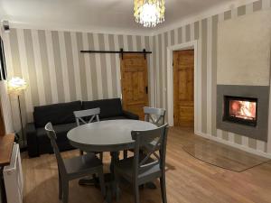 a living room with a table and a couch and a fireplace at Cozy house with fireplace in Jūrmala