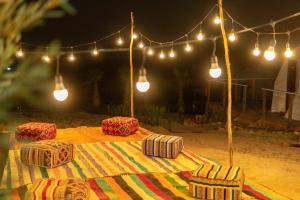 Tamri的住宿－Timlalin Dome，桌子上配有毯子和灯,椅子上