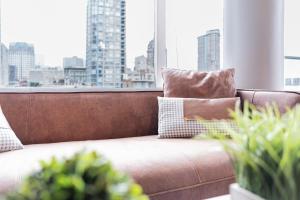 溫哥華的住宿－Amazing Views ! Leather Furniture ! Cozy Condo!，配有大窗户的客房内的棕色沙发