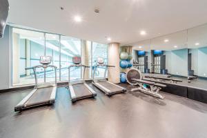 a gym with treadmills and machines in a building at Amazing Views ! Leather Furniture ! Cozy Condo! in Vancouver +22 photos