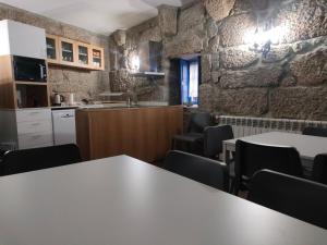 eine Küche und ein Esszimmer mit Tischen und Stühlen in der Unterkunft Quinta de São Simão Turismo e Eventos in Vieira do Minho
