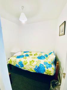 - une chambre dotée d'un lit avec une couverture bleue et jaune dans l'établissement Two Bedroom Property in Central London, à Londres