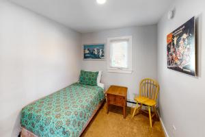 a bedroom with a bed and a table and a chair at Depot Street Condo in Proctorsville