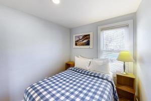 a small bedroom with a bed and a window at Depot Street Condo in Proctorsville