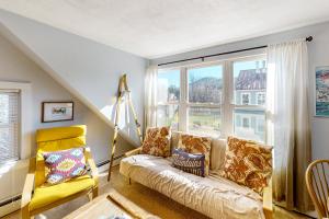 a living room with a couch and a large window at Depot Street Condo in Proctorsville