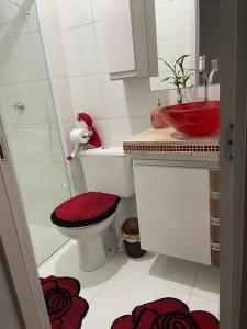 uma casa de banho com um WC, um lavatório e um lavatório vermelho. em Apartamento Mari 4 em São Carlos
