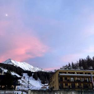 a building in front of a snow covered mountain at Sulle piste da Sergio&Lina in Pila