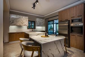 a kitchen with a large island with bar chairs at Eleonas Villa in Fiolítis