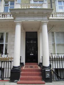 una puerta delantera de una casa blanca con columnas en Queensborough Terrace Serviced Apartments by Concept Apartments en Londres