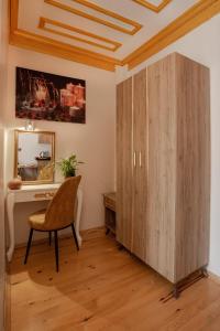 a wooden cabinet in a room with a desk and a chair at April Story Apart Hotel in Istanbul
