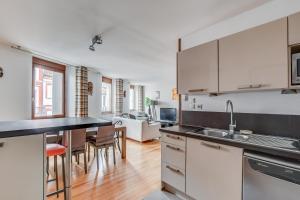 a kitchen with white cabinets and a dining room at Duplex Tolosa - Pont-Neuf, Dôme de la Grave, 2 BDRs 85m2, AC, Free private car park 200m away - T3 85m2 avec clim, parking couvert gratuit à 200m in Toulouse +27 photos