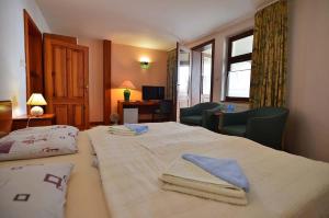um quarto de hotel com uma cama com toalhas em Hotel-EuroPenzión Salaš em Vinné