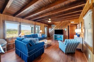 a living room with blue couches and a tv at Bel Isle in Southern Shores