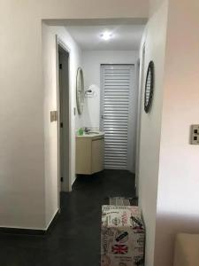 ein weißes Badezimmer mit einem Waschbecken und einem Spiegel in der Unterkunft Apartamento no guaruja- praia enseada in Guarujá