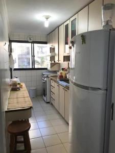 eine Küche mit einem weißen Kühlschrank und einer Theke in der Unterkunft Apartamento no guaruja- praia enseada in Guarujá