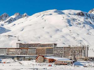 a large building in the snow next to a mountain at Appartement rénové, lumineux avec terrasse, à deux pas des pistes à Tignes le Lac - FR-1-641-11 in Tignes