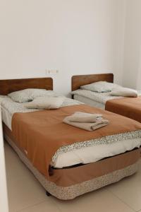 Dos camas en una habitación con toallas encima. en Casa Feliz - RentCar, en Calpe