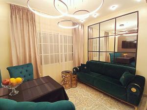 un salon avec un canapé vert et une table dans l'établissement Serenity Gardens 2 BR apartment, à Charm el-Cheikh