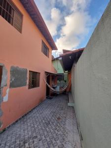 een steegje tussen twee gebouwen met een muur bij Duplex econômico vila ponta negra in Natal