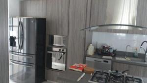 eine Küche mit einem Kühlschrank aus Edelstahl und einem Herd in der Unterkunft Quinta El Diamante in Villavicencio