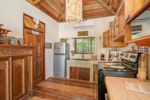 a kitchen with wooden cabinets and a stainless steel refrigerator at Ocho Artisan Bungalows in Tamarindo