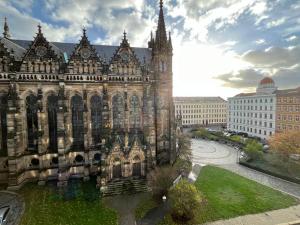 un vieux bâtiment avec une tour dans une ville dans l'établissement Stylisches Studio im Herzen Leipzigs, à Leipzig