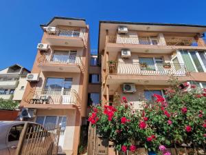 un edificio de apartamentos con flores en los balcones en Guest House Georgieva Ravda en Ravda