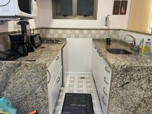 cocina con encimera de granito y fregadero en Apartamento Flat Lagoa, en Río de Janeiro