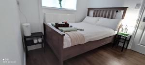 a bedroom with a large bed with a wooden headboard at Surrey Quays Residency - Serviced rooms in London