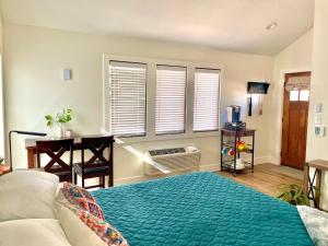 a bedroom with a bed and a desk and windows at Painted Bunting Cabin 15 MIN to MagnoliaBaylor in Elm Mott