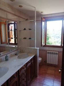baño con 2 lavabos, aseo y ventana en Casa la Nau, en Huesca