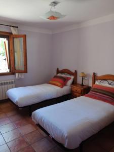 1 dormitorio con 2 camas y ventana en Casa la Nau, en Huesca