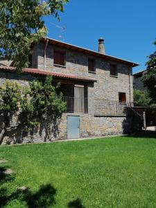 una vista exterior de una casa de piedra con patio en Casa la Nau, en Huesca