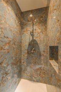 baño con pared de piedra y lámpara de araña en B&B Logie Jolie, en Ypres