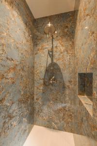 a bathroom with a stone wall with a chandelier at B&B Logie Jolie in Ypres