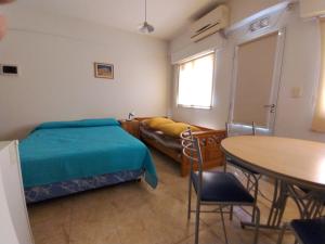a bedroom with a bed and a couch and a table at Center Studio pax 3 apartamento in Trelew