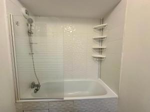 a bathroom with a shower and a tub with a glass door at Agréable 3 pièces avec Parking à La Courneuve Gare by immo Kit bnb in La Courneuve